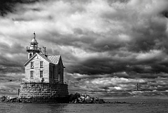 Seabirds Fly Around Stratford Shoal Light Under Dark Clouds